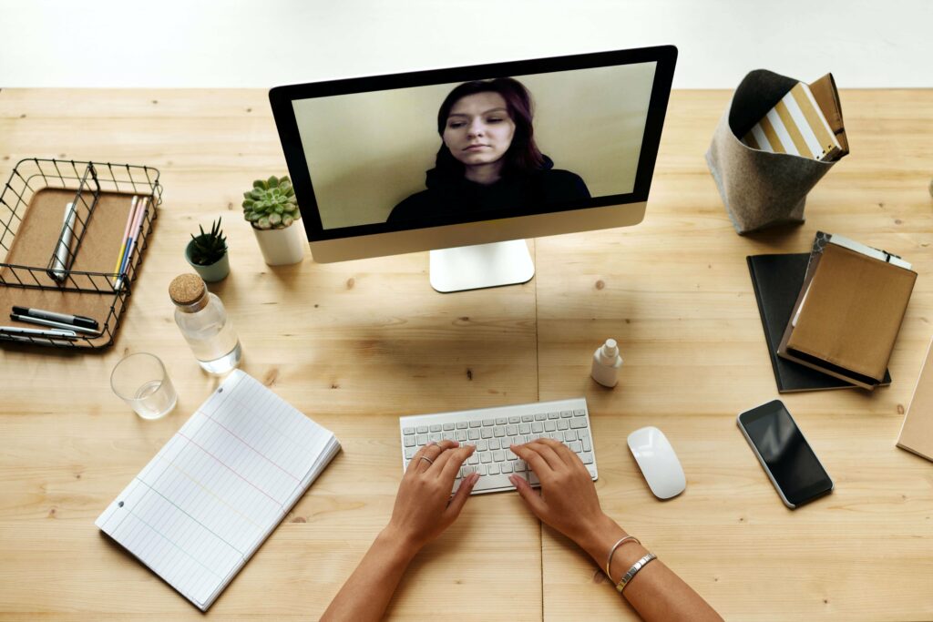 A person talks to a woman on a monitor for a remote job interview.